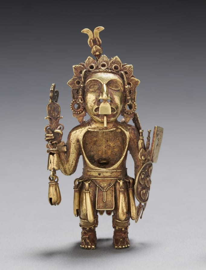 Small gold figure of an Aztec warrior holding a round shield, a dart thrower, and darts, wearing ear ornaments and sandals