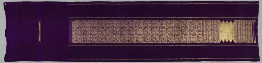 Long purple silk sari with narrow gold borders, a central panel densely brocaded in gold, and a gold end panel with a toothed edge