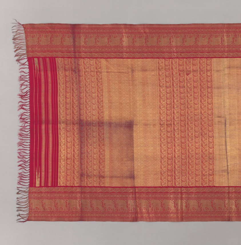 Red and gold silk sari with a fringed end, wide patterned borders, and a gold field woven with vertical bands of small motifs