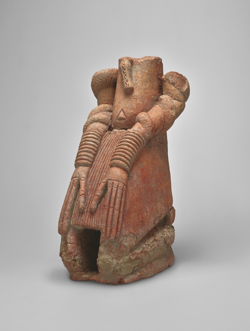 Terracotta kneeling figure from the Inland Niger Delta wearing a long pleated loincloth and stacks of bracelets on both forearms