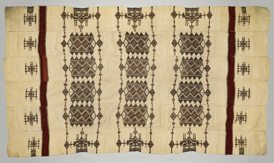 Fulani wool kaasa blanket made of six narrow strips sewn together, cream with dark brown, black, and red geometric motifs