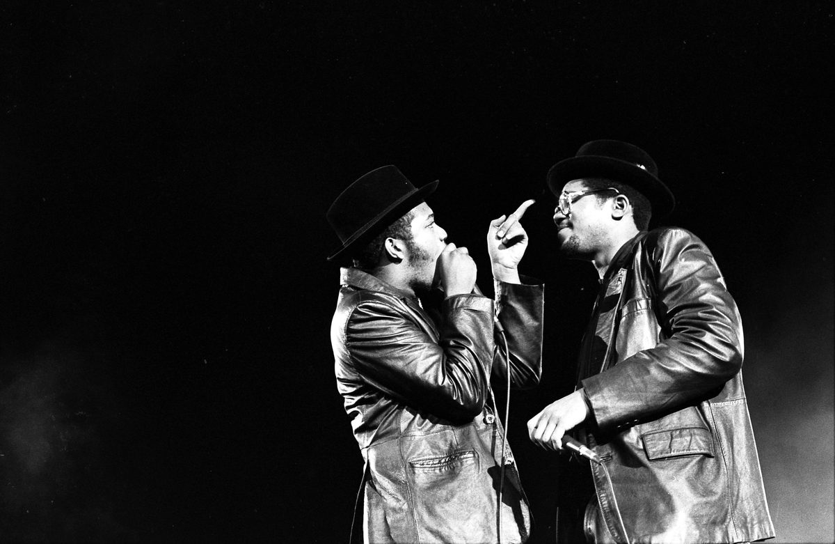 Run-DMC's Joseph Simmons and Darryl McDaniels performing in black leather jackets and fedoras, 1984