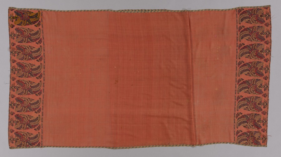 Long Kashmir shawl in apricot wool with a plain center field and wide end panels of dense floral cone motifs in red, blue, and green