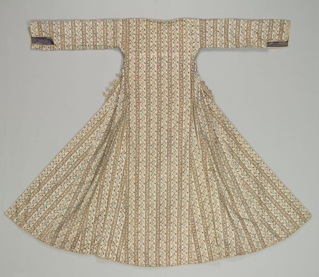 Ottoman woman's robe of ivory silk with narrow vertical stripes of embroidered flowers, long straight sleeves, and a wide flaring skirt