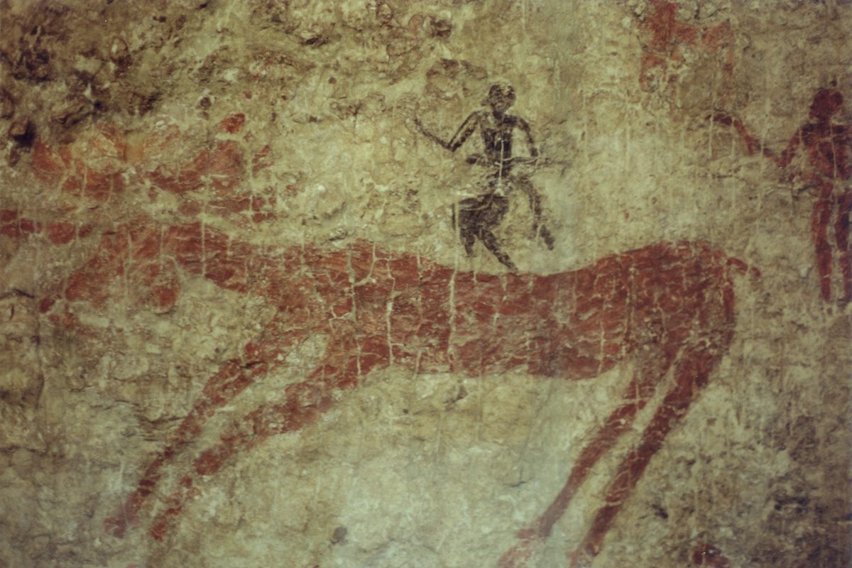 Wall painting of a deer hunt from Çatalhöyük, with human figures around a large red deer