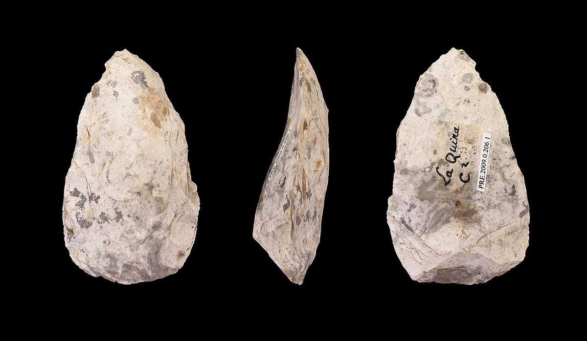 Three views of a pale flint scraper shaped like a teardrop, its edges chipped by retouch, on a black background