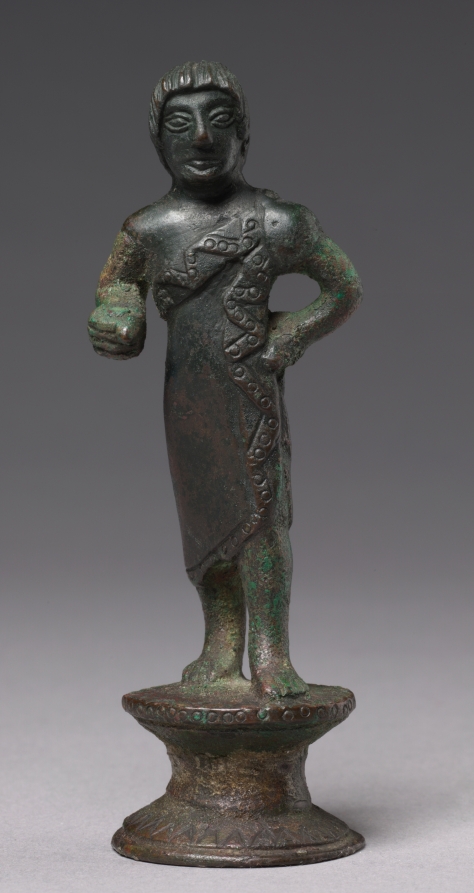 Small bronze Etruscan statuette of a striding young man wrapped in a semicircular cloak with punched circles along its edges