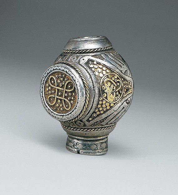Silver ring brooch terminal shaped like a rounded knob, with gold panels of interlace and animal ornament and a niello band at the base